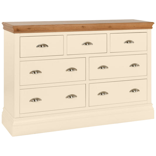 A wide 3 over 4 chest of drawers with a beige body and a wood-colored top, featuring multiple drawers with metal handles.
